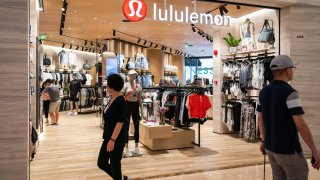 Pedestrians seen walking past Canadian athletic apparel retailer Lululemon in Shanghai.