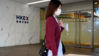 A pedestrian walks past the Hong Kong Stock Exchange (HKEX) on March 23, 2020 in Hong Kong, China.