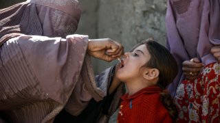In this photo taken on March 20, 2019, an Afghan health worker administers a polio vaccine to a child in the Kandahar province.