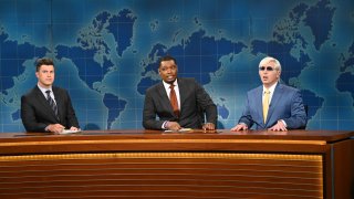 Colin Jost, Michael Che and Beck Bennett sit at anchor desk during the Weekend Update segment on Saturday Night Live.
