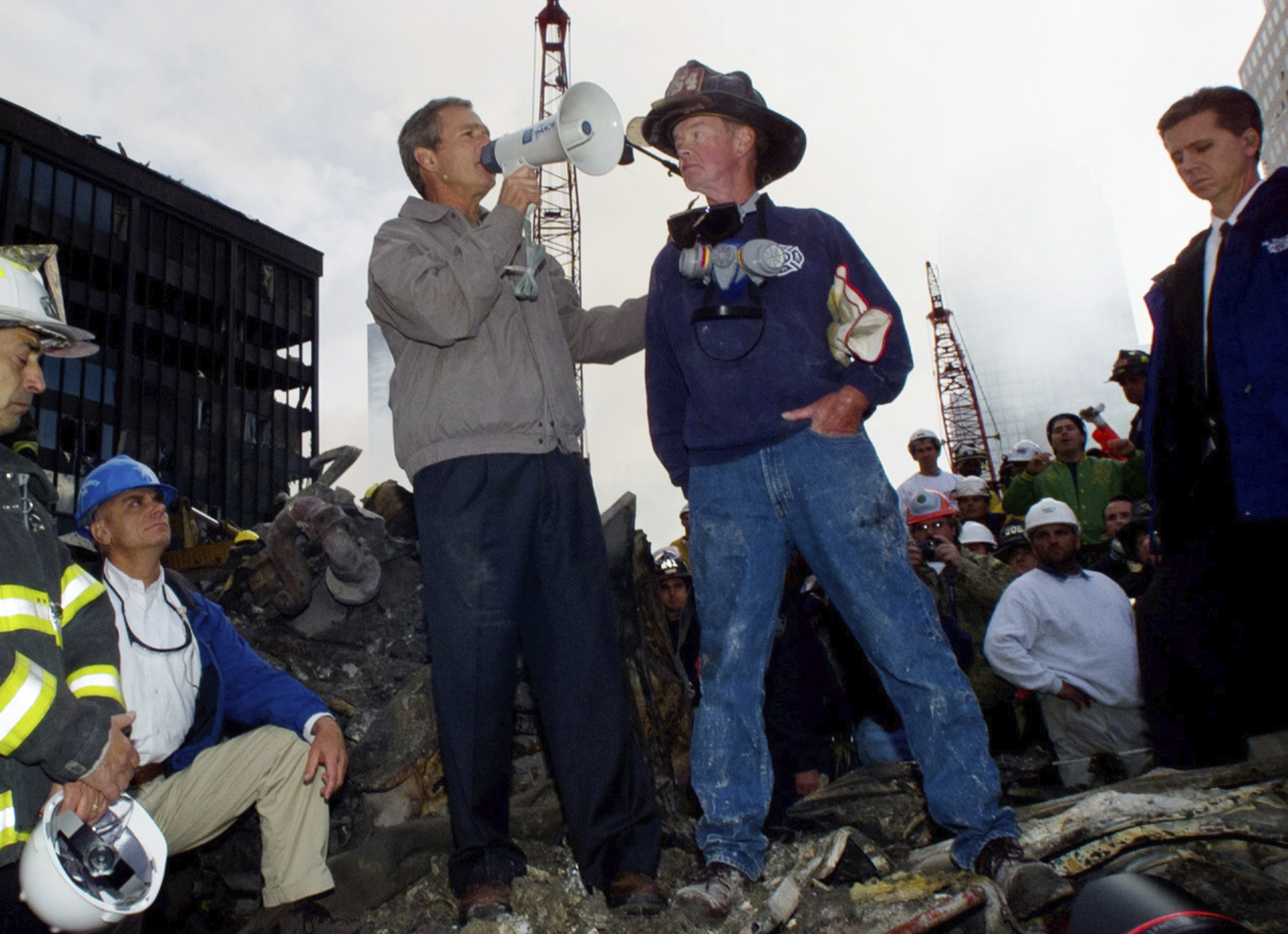 Then-President George W. Bush stands with firefighter Bob Beckwith, right, on a burnt fire truck in front of the World Trade Center during a tour of the devastation on Sept. 14, 2001.