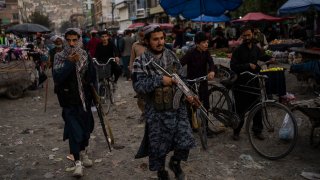 Taliban fighters patrol a market in Kabul's Old City, Afghanistan