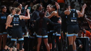 The Chicago Sky, dressed in black uniforms with blue trim and lettering, celebrate a win over the Connecticut Sun in the WNBA semifinals