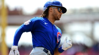 Cubs outfielder Michael Hermosillo, wearing a blue jersey and a blue helmet, runs around the bases in a game against the Cincinnati Reds