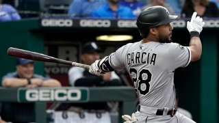 White Sox outfielder Leury Garcia, wearing a gray uniform with black lettering and a black helmet, takes a swing against the Royals