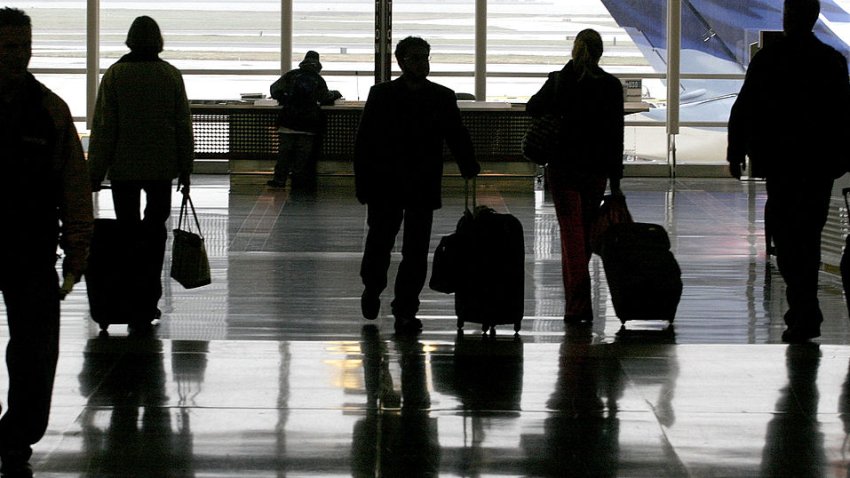 FILE PHOTO: Travelers at airport. (Photo by Chip Somodevilla/Getty Images)