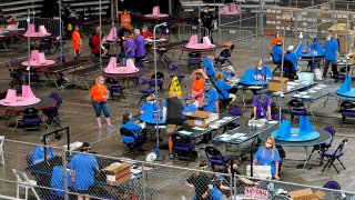 FILE - In this May 6, 2021 file photo, Maricopa County ballots cast in the 2020 general election are examined and recounted by contractors working for Florida-based company Cyber Ninjas at Veterans Memorial Coliseum in Phoenix.