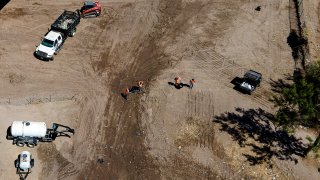 Crews clear an area where migrants, many from Haiti, were encamped along the Del Rio International Bridge, Sept. 24, 2021, in Del Rio, Texas.