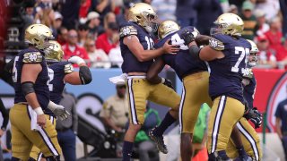 CHICAGO, IL – SEPTEMBER 25: Notre Dame Fighting Irish wide receiver Kevin Austin Jr. (4) celebrates with Notre Dame Fighting Irish quarterback Drew Pyne (10) and teammates after scoring a touchdown during the Shamrock Series game between the Notre Dame Fighting Irish and the Wisconsin Badgers on September 25, 2021 at Soldier Field, in Chicago, IL. (Photo by Robin Alam/Icon Sportswire via Getty Images)
