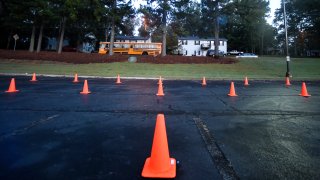 A school bus moves past a COVID-19 teacher test site