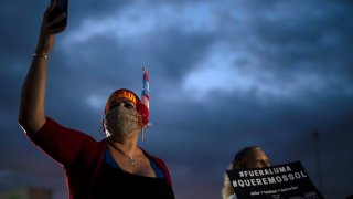 People march along Las Americas Highway to protest the LUMA Energy company in San Juan, Puerto Rico, Friday, Oct. 15, 2021. Ever since LUMA began providing service over the summer, hundreds of thousands of Puerto Ricans have had to deal with widespread blackouts for extended periods of time, voltage fluctuations and bad customer service along with an increase in pricing.