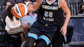 Chicago Sky guard Courtney Vandersloot drives toward the basket, with the ball in her right hand and while wearing a black uniform with blue trim and lettering