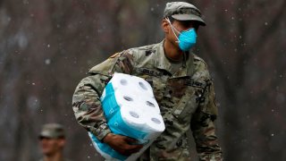 A member of Joint Task Force 2, composed of soldiers and airmen from the New York Army and Air National Guard, wears a face mask while carrying paper towels as he arrives to sanitize and disinfect the Young Israel of New Rochelle synagogue, as snow falls during the coronavirus disease (COVID-19) outbreak in New Rochelle, New York, March 23, 2020.