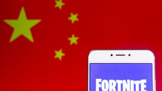 The Fortnite logo displayed on a smartphone with the flag of China shown in the background.