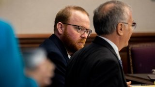 Travis McMichael, center, listens to his attorney Bob Rubin, right, during his trial in the Glynn County Courthouse, Nov. 16, 2021, in Brunswick, Ga.