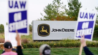 FILE – Members of the United Auto Workers strike outside of a John Deere plant, Wednesday, Oct. 20, 2021, in Ankeny, Iowa.