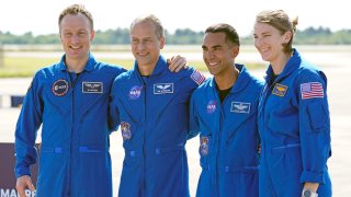 FILE - From left, European Space Agency astronaut Matthias Maurer of Germany, and NASA astronauts Tom Marshburn, Raja Chari, and Kayla Barron gather for a photo after arriving at the Kennedy Space Center in Cape Canaveral, Fla., on Tuesday, Oct. 26, 2021. A medical issue has sidelined one of four astronauts assigned to SpaceX’s upcoming flight to the International Space Station and delayed the launch, officials said Monday, Nov. 1, 2021.