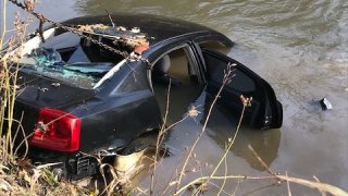 A photo shows the black Dodge Charger allegedly driven by a suspect into the Iroquois River on Nov. 9, 2021.