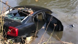 A photo shows the black Dodge Charger allegedly driven by a suspect into the Iroquois River on Nov. 9, 2021.