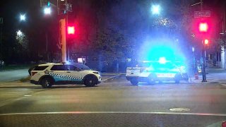 Two Chicago police cars sit near an intersection at 47th and King Drive after a shooting