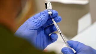 FILE - A healthcare worker fills a syringe with the Pfizer COVID-19 vaccine at Jackson Memorial Hospital, Oct. 5, 2021, in Miami. Nearly 8,500 active duty members of the Air Force and Space Force have missed the deadline for getting COVID-19 vaccinations, including 800 who flatly refused and nearly 5,000 with pending requests for a religious exemption, the Air Force said Wednesday, Nov. 3.