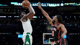 Boston Celtics guard Jaylen Brown (7) shoots a 3-point shot over New York Knicks forward Wayne Selden (11) during the first half of an NBA basketball game, Saturday, Dec. 18, 2021, in Boston.