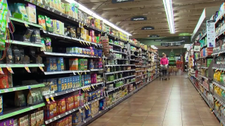 A shopper searches for food at a grocery store.