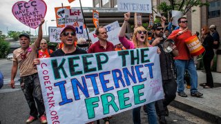 Protesters march past the FCC headquarters before the Commission meeting on net neutrality proposal on May, 15, 2014 in Washington, DC.