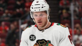 Blackhawks defenseman Jake McCabe is pictured wearing the team's road uniform, with a white jersey and a white helmet