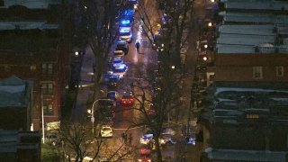 An aerial view of Langley Avenue in Chicago as police investigate a shooting, with officers shining flashlights up and down the street