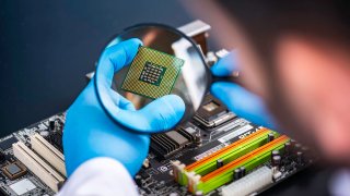 A technologist inspects a computer chip.