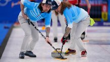 Christopher Plys, left, and Matt Hamilton sweep the ice