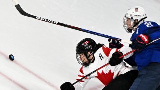 USA women and canada battle for puck