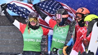 USA's Nick Baumgartner (2nd L) holds his national flag with USA's Lindsey Jacobellis (L) after winning the snowboard mixed team cross big final during the 2022 Winter Olympics at the Genting Snow Park P & X Stadium in Zhangjiakou, China on Feb. 12, 2022.