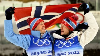winner Johannes Thingnes Bö (r) and third-placed Tarjej Bö, both from Norway, cheer during the flower ceremony after men's 10km sprint.