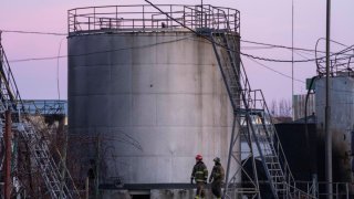 Firefighters work at the site in the aftermath of the first strike that involved Russian rockets that hit an oil facility in an industrial area in the northeastern outskirts of Lviv, Ukraine, Sunday, March 27, 2022.