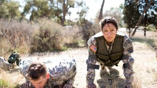 Army woman and man doing pushups