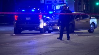Crime scene tape surrounds two vehicles after a Chicago police officer was shot and another was pinned between the vehicles on March 28 in Lawndale.