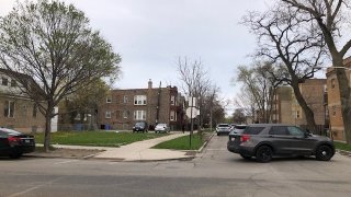 A silver police cruiser sits in front of a T-shaped intersection in Chicago's West Garfield Park.