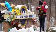 FILE - Students hug at a memorial at Oxford High School in Oxford, Mich., Dec. 1, 2021. Authorities say a 15-year-old sophomore opened fire at Oxford High School, killing four students and wounding seven other people Nov. 30, 2021. The May 2022 shooting rampage in a Buffalo supermarket, carried out by an 18-year-old who was flagged for making a threatening comment at his high school the year before, highlights concerns over whether schools are adequately supporting and screening students.