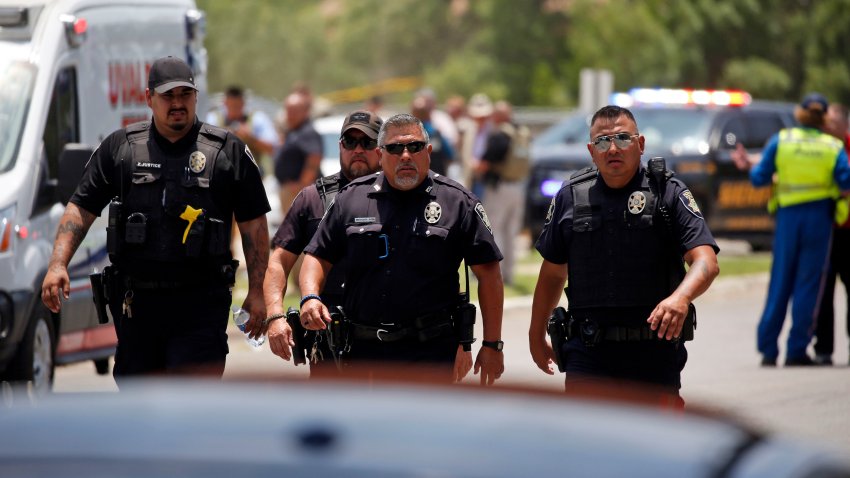 Police walk near Robb Elementary School following a shooting, Tuesday, May 24, 2022, in Uvalde, Texas.