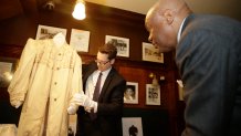 Former San Francisco Mayor Willie Brown (right) looks on as curator Kevin Jones with the Fashion Institute of Design and Merchandising, unveils a rare period coat