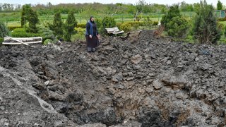 Orthodox Sister Evdokia gestures in front of the crater of an explosion, after Russian shelling next to the Orthodox Skete in honour of St. John of Shanghai in Adamivka, near Slovyansk, Donetsk region, Ukraine, Tuesday, May 10, 2022.