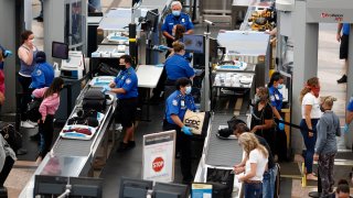 FILE - Transportation Security Administration agents process passengers at the south security checkpoint at Denver International Airport in Denver on June 10, 2020. The chief of the TSA said Tuesday, May 10, 2022, that his agency has quadrupled the number of employees who could bolster screening operations at airports that become too crowded this summer.