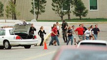 Students run from Columbine High School run under cover from police