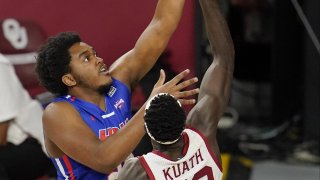 Houston Baptist guard Darius Lee, left, shoots over Oklahoma forward Kur Kuath (52) in the first half of an NCAA college basketball game Saturday, Dec. 19, 2020, in Norman, Okla.