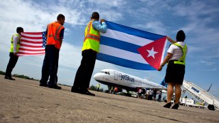 FILE - Airport workers receive JetBlue flight 387, the first commercial flight between the U.S. and Cuba in more than a half century, holding a United States, and a Cuban national flag, on the airport tarmac Wednesday, Aug. 31, 2016 in Santa Clara, Cuba. The U.S. Transportation Department on Wednesday, June 1, 2022 lifted restrictions on flights to Cuba that were established during the Trump administration. The restrictions had prevented U.S. airline flights and chartered flights from going to Cuban cities other than Havana.