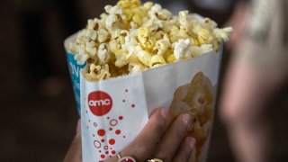 A person carries popcorn at the AMC Lincoln Square 13 movie theater