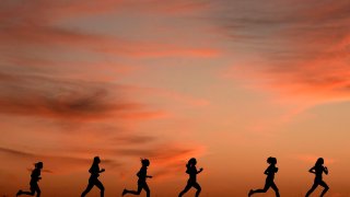 High school students run at sunset