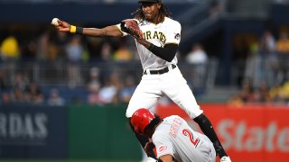 Oneil Cruz #15 of the Pittsburgh Pirates turns a double play in front of Jose Barrero #2 of the Cincinnati Reds during the fifth inning at PNC Park on August 19, 2022, in Pittsburgh, Pennsylvania.